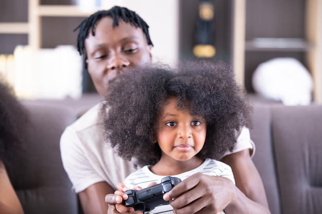 Afroamerikanischer Papa spielt Spiel mit Tochter Schwarzafrikanische Familie Glücklicher afroamerikanischer Vater und kleine Tochter