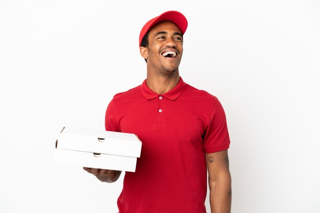 Afroamerikanischer Pizzabote, der Pizzakartons über isolierter weißer Wand abholt