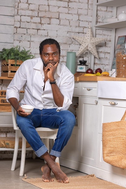 Afroamerikanischer schwarzer Mann, der Frühstück oder Mittagessen in der Küche zu Hause kocht, gesundes Lebensmittelkonzept
