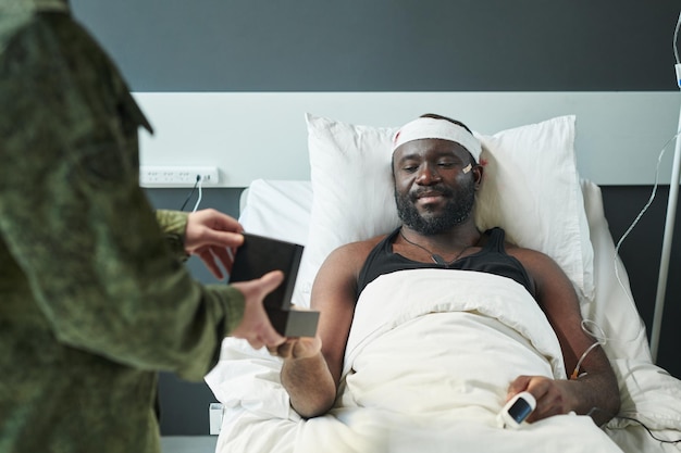 Afroamerikanischer Soldat mit verletztem Kopf, der auf die Medaille in einer kleinen Schachtel blickt