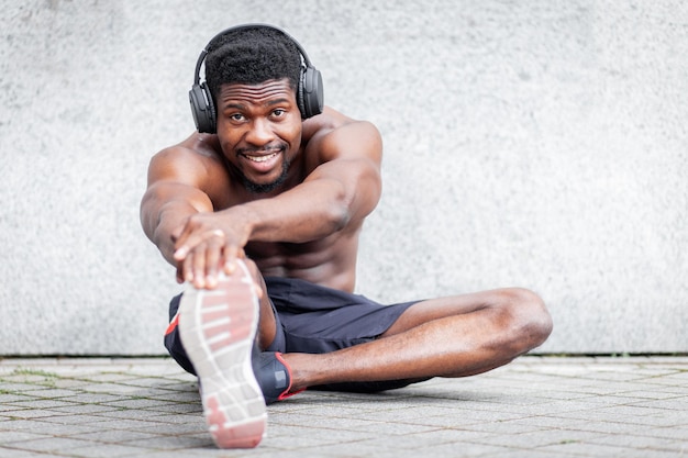 Foto afroamerikanischer sportler macht sport im freien gegen wandsportler macht körperliche bewegung