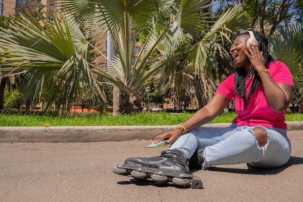 Afroamerikanischer Teenager, der mit Kopfhörern und Handy Musik hört