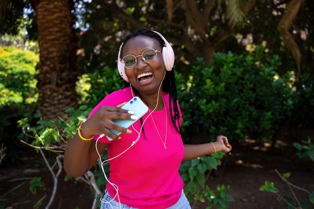 Afroamerikanischer Teenager, der mit Kopfhörern und Handy Musik hört