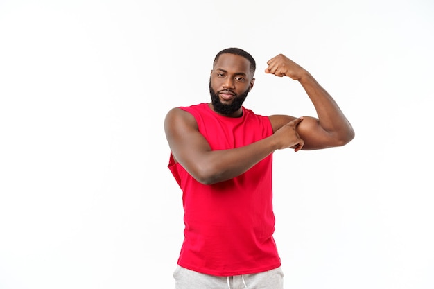 Afroamerikanischer Teenager zeigt Muskeln am Arm. Isoliert auf weißem Hintergrund. Studioportrait. Übergangsalter Konzept.