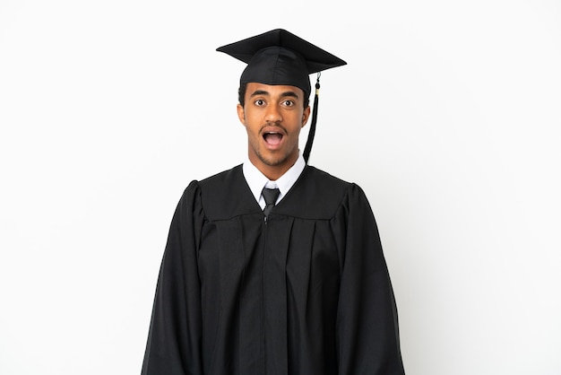 Afroamerikanischer Universitätsabsolvent über isoliertem weißem Hintergrund mit überraschtem Gesichtsausdruck