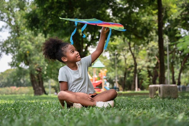 Afroamerikanisches Mädchen spielt Drachen im Park