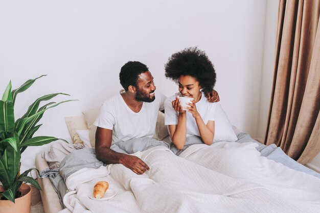 Afroamerikanisches Paar im Bett Echt schönes und fröhliches Liebespaar zu Hause