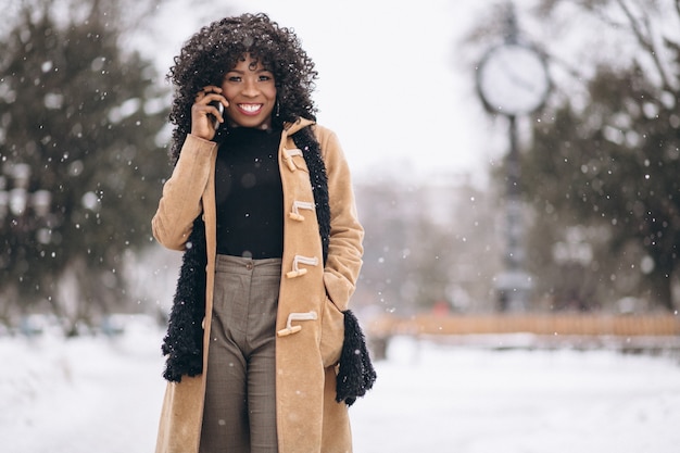 Afroe-amerikanisch Frau mit Telefon im Winter