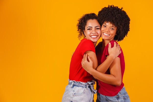 Afrolesbisches Paar auf Gelb. homo-affektives paar