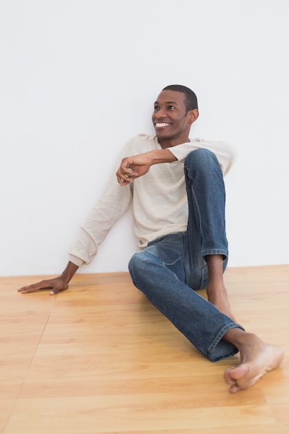 Afromann, der auf Boden sitzt, wie er zur Wand oben schaut