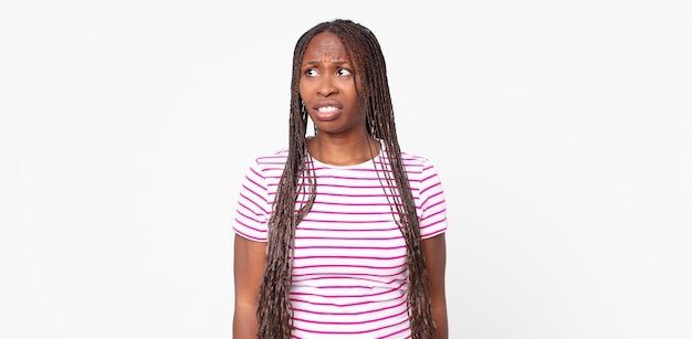 Afroschwarze erwachsene Frau, die besorgt, gestresst, ängstlich und ängstlich aussieht, in Panik geraten und die Zähne zusammenbeißt