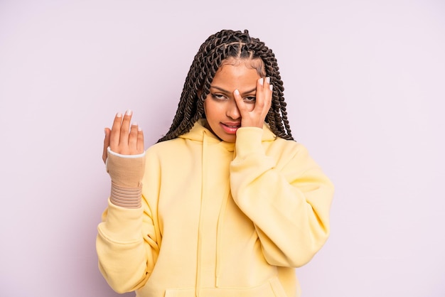 Afroschwarze Frau mit Zöpfen und gebrochener Hand