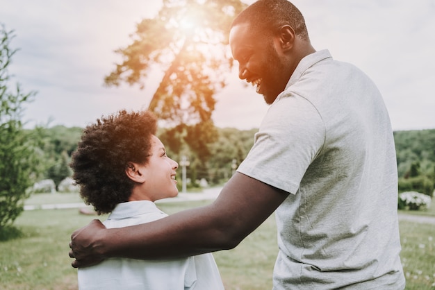 Afrovater umarmt seinen Sohn und schaut auf Jungen