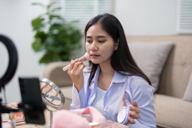 Agente de belleza aplicando lápiz labial durante un tutorial de maquillaje en vivo