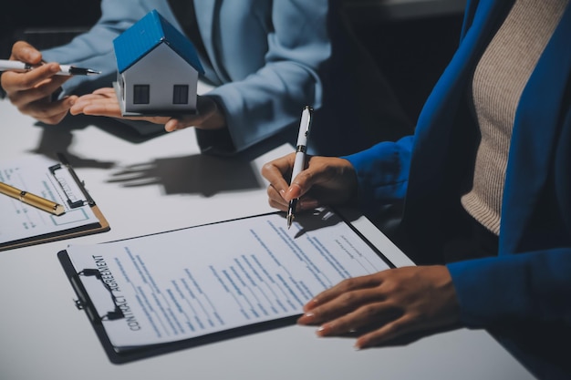 Agente de bienes raíces y contrato de firma del cliente para comprar un seguro de vivienda o un préstamo inmobiliario