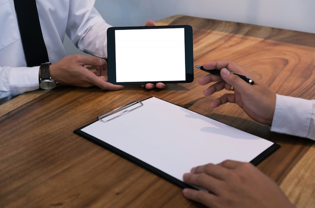 Agente de bienes raíces que muestra la tableta de pantalla de banco blanco al cliente.