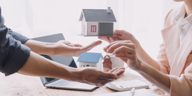 Agente de bienes raíces que presenta y consulta al cliente para la toma de decisiones, firmar un acuerdo de formulario de seguro, comprar y vender el modelo de vivienda en relación con la oferta de préstamo hipotecario y el seguro de la vivienda