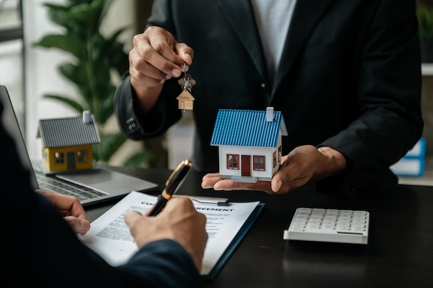 Agente de bienes raíces que presenta y consulta al cliente para la toma de decisiones firmar un acuerdo de formulario de seguro modelo de hogar relacionado con la oferta de préstamo hipotecario