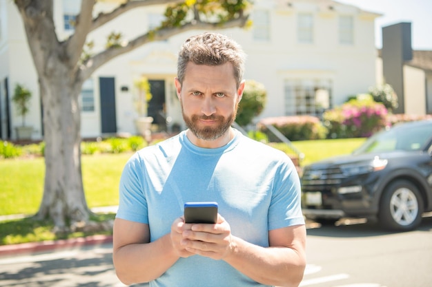 El agente de bienes raíces trabaja en línea en el alquiler de teléfonos inteligentes o compra un automóvil nuevo, asegura la propiedad, promoción de seguros, concesionario sonriente, gerente de ventas estadounidense, agente de bienes raíces en el automóvil a la venta.