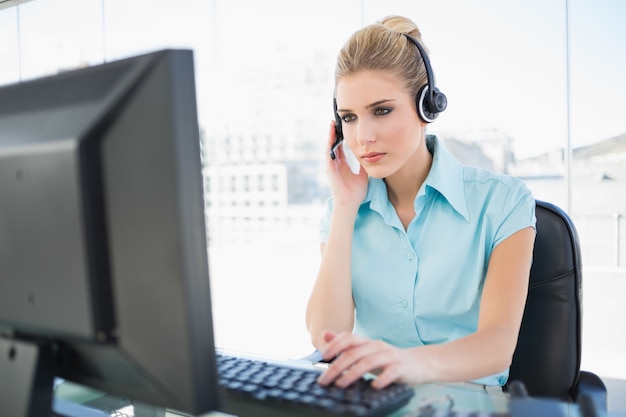 Agente concentrado de call center trabalhando no computador