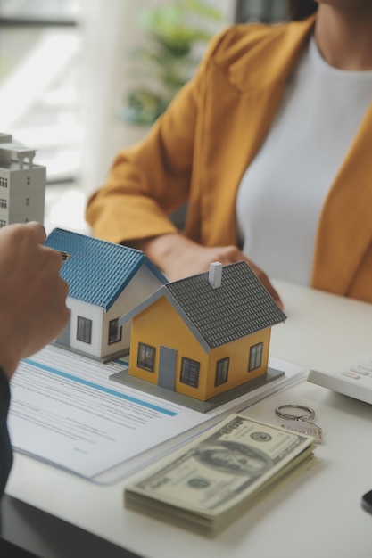 Foto agente de corretaje de bienes raíces entregar una muestra de una casa modelo al contrato de préstamo hipotecario del cliente arrendar y comprar y vender casa y contratar el concepto de préstamo hipotecario de seguro de hogar