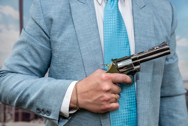 Foto agente de closeup em terno azul segurando arma de pistola semiautomática