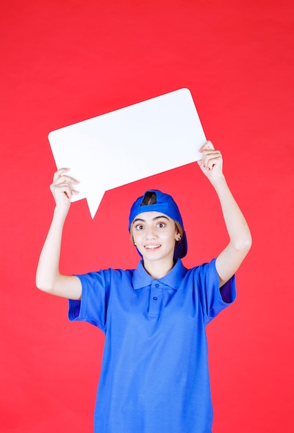 Agente de serviço feminino de uniforme azul, segurando um balcão de informações retângulo sobre a cabeça.