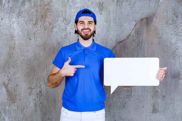 Agente de serviço masculino de uniforme azul segurando um quadro retangular de informações