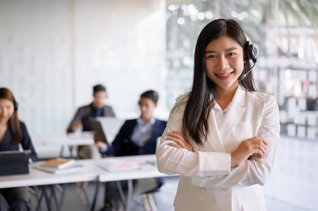 Agente de serviços ao cliente feminino confiante com fone de ouvido trabalhando em um escritório de call center.