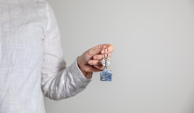 Agente imobiliário com modelo de casa e chaves vendendo o conceito de hipoteca do proprietário da casa com cópia