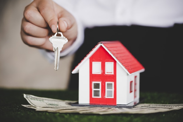 Agente imobiliário com modelo de casa e chaves