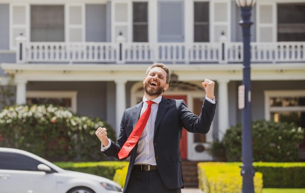 Agente imobiliário dando as boas-vindas aos visitantes perto do novo retrato da casa de um corretor de imóveis animado