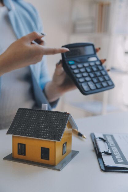 Agente imobiliário e cliente assinando contrato para comprar seguro de casa ou empréstimo imobiliário