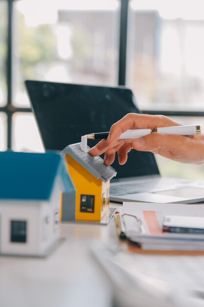 Foto agente imobiliário entrega de amostras de casas a clientes contratos de empréstimo hipotecário fazer um contrato de compra e venda de uma casa e contratos de seguro de casa conceitos de empréstimos hipotecários de casa