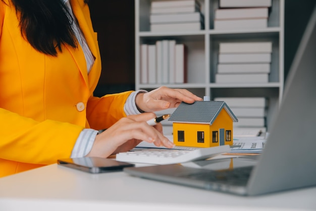 Foto agente imobiliário entrega de amostras de casas a clientes contratos de empréstimo hipotecário fazer um contrato de compra e venda de uma casa e contratos de seguro de casa conceitos de empréstimos hipotecários de casa