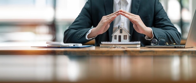 Agente imobiliário entrega modelo de casa para proteção e cuidados Conceito de seguro de propriedade