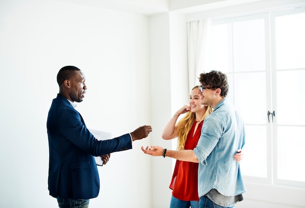 Agente imobiliário entregando a chave da casa aos clientes