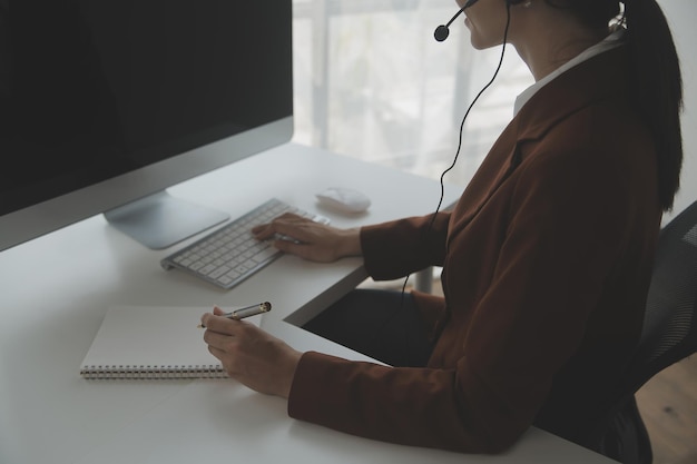 Agente jovem operador amigável com fones de ouvido trabalhando em um call center