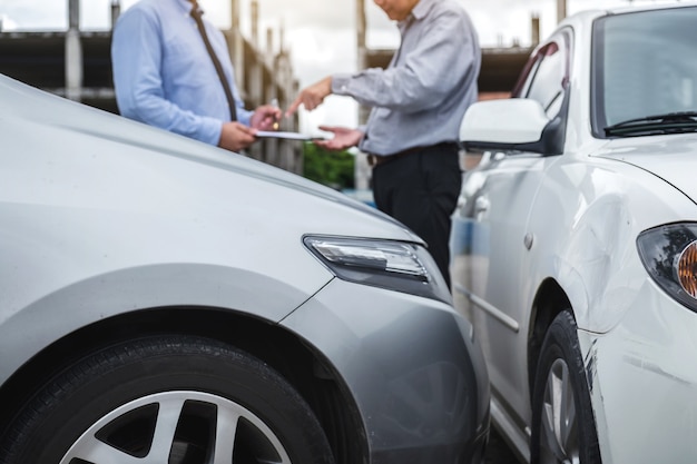 Agente de seguros trabajando en formulario de informe con proceso de reclamo de accidente de automóvil