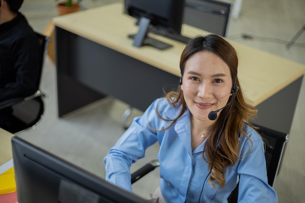 Foto agente de telemarketing asiático en la oficina del centro de llamadas