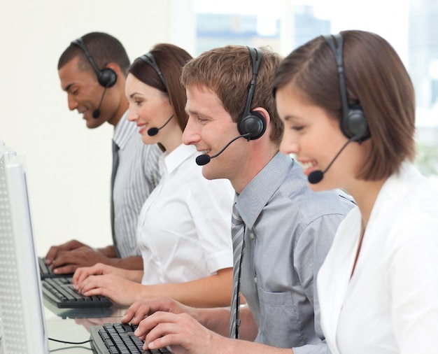Agentes de atención al cliente concentrados que trabajan en un centro de llamadas