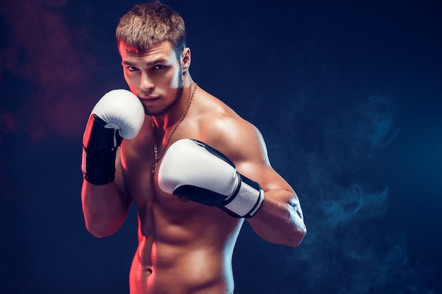 Aggressiver hemdloser Boxer auf grauem Hintergrund.