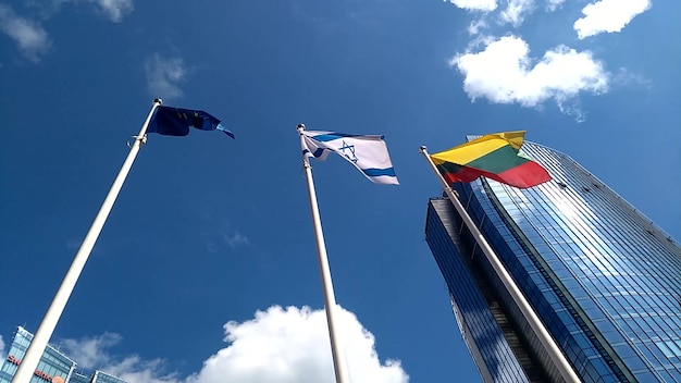 Agitando a bandeira da União Europeia, a bandeira de Israel e a bandeira da Lituânia ao vento