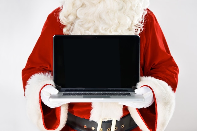 Agora você pode digitar sua lista de desejos Retrato recortado do Pai Natal segurando um laptop isolado em branco