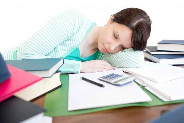 Agotado brillante mujer estudiando en una mesa