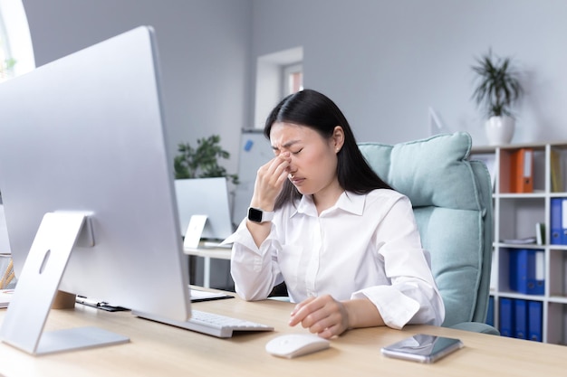 Agotamiento en el trabajo cansado joven mujer asiática empresaria gerente contable independiente se sienta en un