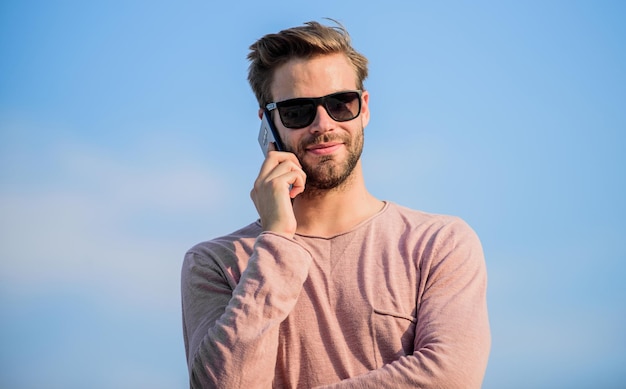 Agradable conversación. hombre seguro de hablar por teléfono. Llamar a un amigo. hombre macho usa teléfono móvil. tecnología moderna en la vida. siempre en contacto. Fondo de cielo de hombre sexy. chico estilo casual. Modelo.