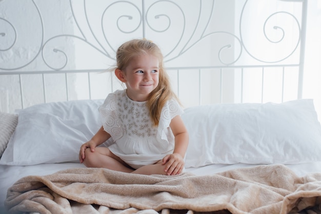 Agradable despertar para una niña, Girl se ve alegre y llena de energía por la mañana.