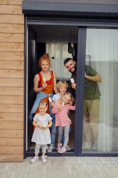 Agradable familia alegre de pie en la puerta