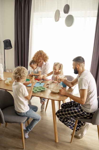 Foto agradable familia unida sentados juntos a la mesa